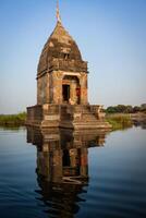 pequeno hindu têmpora dentro a meio do a piedosos narmada rio, maheshwar, madhya pradesh estado, Índia foto