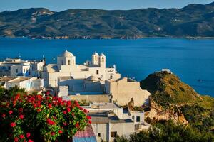 pitoresco cênico Visão do grego Cidade Plaka em milos ilha sobre vermelho gerânio flores foto
