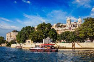 toruísta barco em lago pichola com cidade Palácio dentro fundo. udaipur, Índia foto