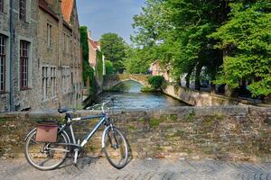 bicicleta em uma ponte perto canal e velho casas. Bruges Brugge , Bélgica foto