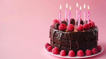 uma aniversário chocolate camada bolo com velas e Rosa fundo. foto