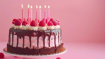 uma aniversário chocolate camada bolo com velas e Rosa fundo. foto