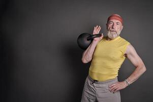 Atlético Senior homem Treinamento com uma pesado kettlebell foto