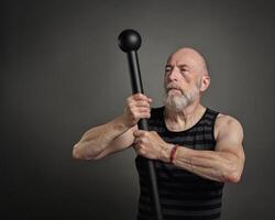 Senior homem é exercício com aço maça foto