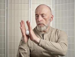 Senior homem é praticando reflexologia terapia foto