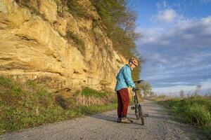 Senior masculino ciclista equitação uma dobrando bicicleta em barco a vapor vestígio, bicicleta trilha convertido a partir de a abandonado Ferrovia, perto Peru, nebrasca, primavera manhã cenário foto