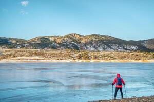 caminhante às congeladas montanha lago foto