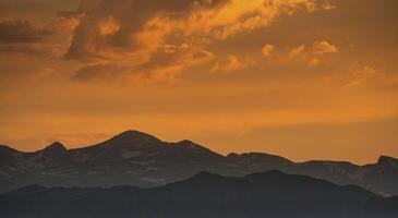 silhueta do montanhas contra pôr do sol céu foto