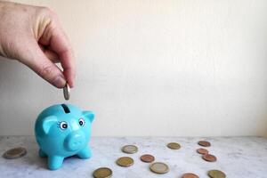 alimentando a porquinho banco com euro moedas foto