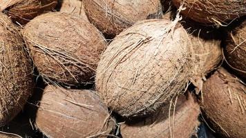 uma pilha de cocos no mercado de alimentos. foto macro de coco de frutas tropicais. textura de frutas de coco peludo nozes. cocos na casca.