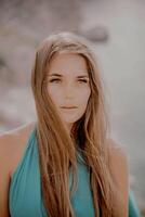 mulher mar verde vestir. retrato do uma feliz mulher com grandes cabelo dentro uma grandes hortelã vestir posando em uma de praia com calma mar bokeh luzes em ensolarado dia. menina em a natureza em azul céu fundo. foto