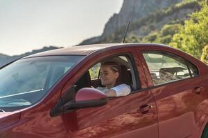 mulher dirigindo uma carro. uma senhora dentro oculos de sol leva a roda do dela foto