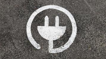 símbolo do carregador elétrico para carros, em um estacionamento público foto