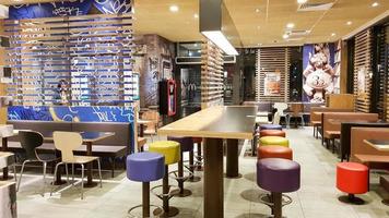 ucrânia, kiev - 19 de agosto de 2019. interior do restaurante mcdonald's. a mcdonald's é a maior rede de restaurantes fast food do mundo com base nos eua. interior com mesas altas e bancos de bar coloridos foto