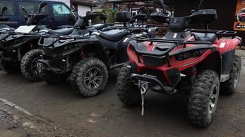 ucrânia, yaremche - 20 de novembro de 2019. muitos atvs estacionados em uma estrada de terra, close-up. carro de quatro rodas, veículo todo-o-terreno. rodas grandes com pernas poderosas. passeio de montanha nos Cárpatos. foto