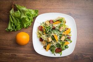 legumes saudável salada, laranja, tomates, ruccola e queijo foto