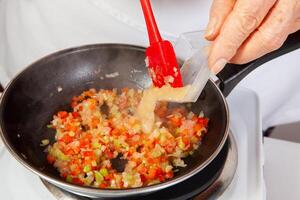 preparação do a tradicional colombiano Hogao ou criollo molho fez do cebola, tomate, pimentas e coentro. salsa criolla foto