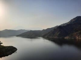 uma lindo dia Visão do wadi qanuna barragem dentro al bahá, saudita arábia. a água do a barragem e a em torno da colinas estão apresentando uma lindo cena dentro a luz solar. foto