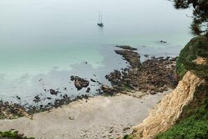 nebuloso dia em a costa com verde Relva em a pedras crozon, França 29 pode 2018 foto