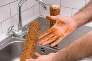 mão segurando sujo água filtro cartucho sobre a afundar. Castanho coloração. evidência do contaminação do toque água com ferro cátions. foto