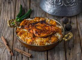 frango mandi Biryani servido dentro prato lado Visão em de madeira mesa fundo foto