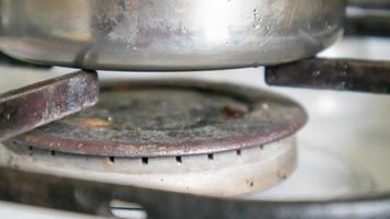 Fogão a gás sujo na cozinha para cozinhar com manchas de óleo vegetal e restos de comida queimada na superfície, close-up. foco seletivo. Fogão a gás coberto de graxa na cozinha. foto