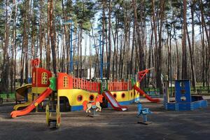 crianças slides e balanços às a Parque infantil dentro a cidade parque foto