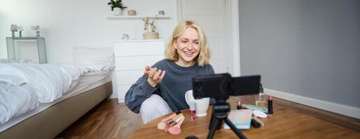 retrato do jovem Adolescência menina dentro dela sala, gravação uma vlog, diariamente estilo de vida para social meios de comunicação, Internet influenciador publicidade produtos on-line, falando para a Câmera, sentado em a chão foto