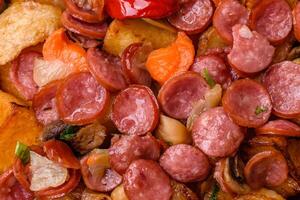 grelhado batatas cortar para dentro fatias com Caçando salsichas com alho, cebola foto