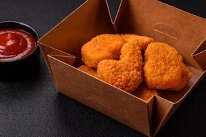 deliciosos nuggets de frango crocantes frescos em um fundo escuro de concreto foto