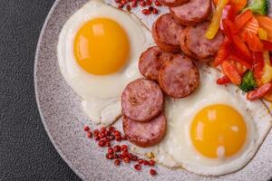 delicioso nutritivo café da manhã com frito ovos, salsicha, cozido no vapor legumes foto