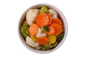 delicioso fresco legumes brócolis, couve-flor, cenouras cozido no vapor com sal foto
