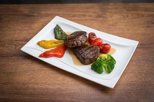 bife com grelhado legumes e tempero em servindo prato foto