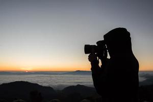 fotógrafo matinal acampando no fundo da montanha foto