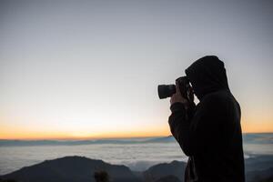 fotógrafo matinal acampando no fundo da montanha foto