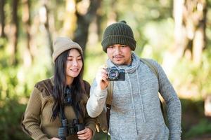 jovem casal turista viajar em floresta montanhosa foto