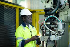 retrato do uma técnico trabalhando com uma digital multímetro para teste a elétrico sistema do uma enorme o circuito borda às a industrial plantar usando a automatizado mão robô. foto