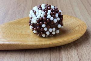 brigadeiro, brigadeiro, chocolate doce típico da culinária brasileira coberto por partículas, em fundo de madeira. foto