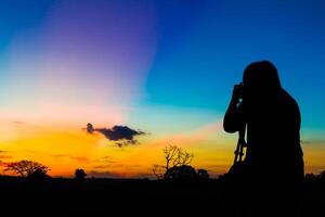 silhueta fotógrafo com pôr do sol foto