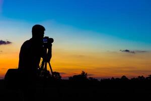 silhueta fotógrafo com pôr do sol foto