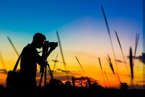 silhueta fotógrafo com pôr do sol foto