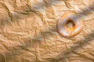 donuts caseiros frescos com açúcar em pó no papel manteiga. conceito de padaria americana. foto