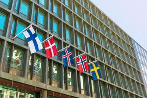 bandeiras dos principais países escandinavos na fachada de um edifício moderno de hotel. da esquerda para a direita - finlândia, dinamarca, islândia, noruega, suécia