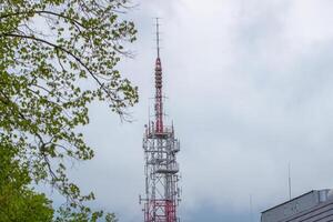 uma alta torre com uma vermelho e branco antena foto