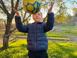 a mãos do jovem futebol jogador aguarde a bola para lançar dentro acima dele cabeça. foto