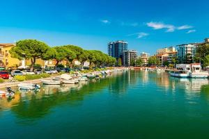 paisagem urbana de grado, itália. vista de um canal com barcos a motor caídos na água foto