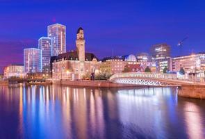 uma vista de uma cidade à noite. um panorama noturno de malmo é refletido na água, na Suécia. foto de longa exposição com reflexos suaves e agradáveis