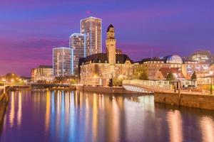 paisagem urbana à noite de malmo, suécia. edifícios históricos modernos e antigos refletidos na água. pôr do sol pitoresco em uma cidade foto