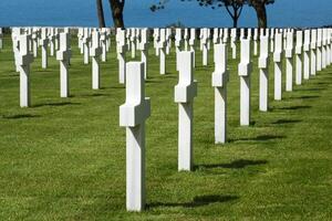 americano cemitério às normandia área. sepultura com azul oceano dentro primeiro plano às segunda guerra mundial memorial. foto
