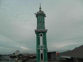 foto do a mesquita torre ocupado a partir de a topo chão do uma de vários andares prédio. a mesquita torre é usava Como uma marcador e Além disso Como uma Alto-falante